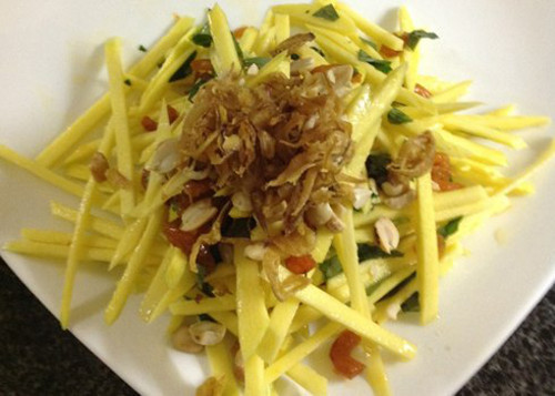 Gỏi xoài kiểu Thái. Món gỏi xoài xanh này sẽ giúp bạn giải nhiệt và ăn ngon miệng hơn trong những ngày nắng nóng. Xoài xanh thái sợi dài, nhỏ. Đậu đũa cắt khúc khoảng 2cm, cà chua bi cắt đôi.Cho xoài, đậu đũa, đậu phộng rang, tôm khô, tỏi ớt vào cối, giã nhẹ cho mềm. Ảnh: megafun