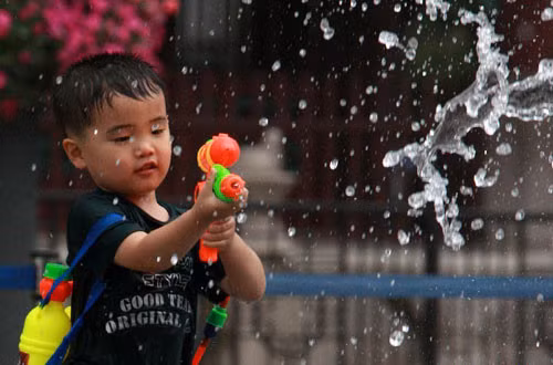 Có thể hướng dẫn con chơi các trò chơi như phun mưa với cốc nước, thổi bong bóng với các loại ống hút, tập thở với chậu nước để giúp bé làm quen với nước. Ảnh: zing