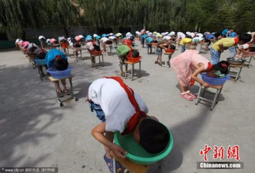 Một cách khác cũng giúp bé làm quen với nước là hướng dẫn các bé vốc nước lên mặt tự rửa rồi thấm lại bằng khăn, thay vì mẹ dùng khăn rửa cho bé. Ngoài ra, cha mẹ cùng con thi xem ai "lặn' lâu hơn bằng cách úp mặt vào một bát nước cũng là phương pháp giúp bé tiếp cận với nước nhanh hơn. Ảnh: chinanew