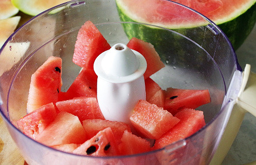 Kem dưa hấu tự làm vừa thơm ngon, an toàn, lại có công dụng tích cực trong việc hỗ trợ giảm cân. Dưa hấu cắt miếng nhỏ rồi cho vào máy xay sinh tố cùng một ít đường, nước cốt chanh. Xay thật mịn rồi đổ vào một cái ray để lọc lấy nước. Ảnh: bepgiadinh