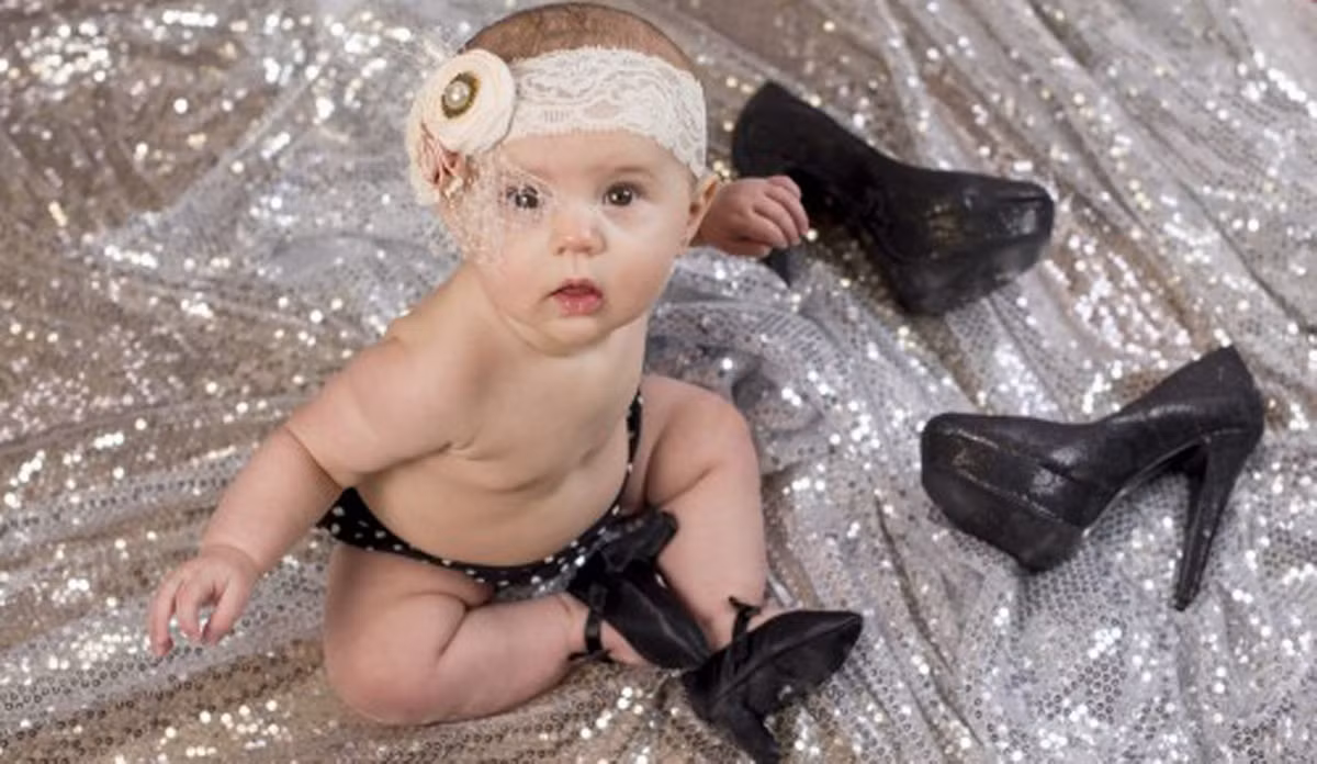 Không chỉ cho trẻ đi giày cao gót, bộ ảnh còn cho thấy, những em bé mặc đồ lót làm bằng tơ lụa mềm quảng cáo sản phẩm.