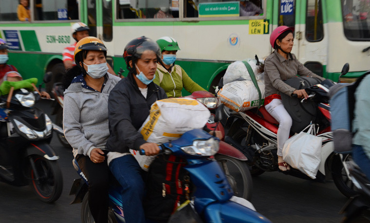 Người dân lỉnh kỉnh hành lý về quê bằng xe máy để nghỉ Tết.