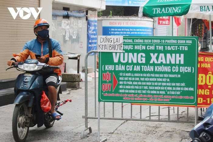 Tại một vùng xanh trên địa bàn quận Cầu Giấy, shipper giao hàng vẫn thản nhiên ra vào chốt. Theo như quy định tại vùng xanh, hàng hóa chỉ được giao tại chốt, thế nhưng việc quản lý vùng an toàn này lại trở nên lỏng lẻo.