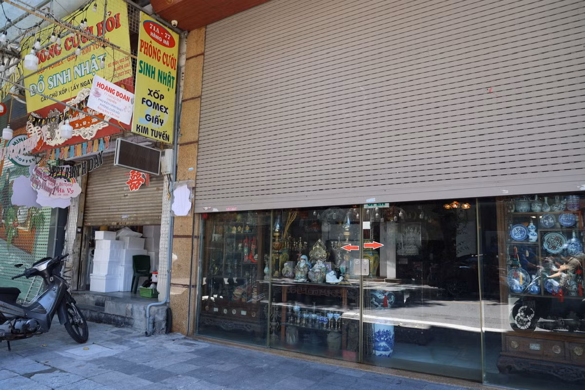 Một số cửa hàng vẫn tranh thủ mở hé cửa để bán hàng cho khách.