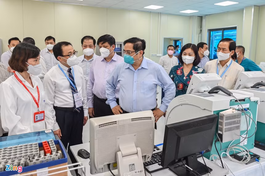 Thủ tướng Phạm Minh Chính kiểm tra hệ thống máy xét nghiệm Covid-19 tại phòng lab của bệnh viện.