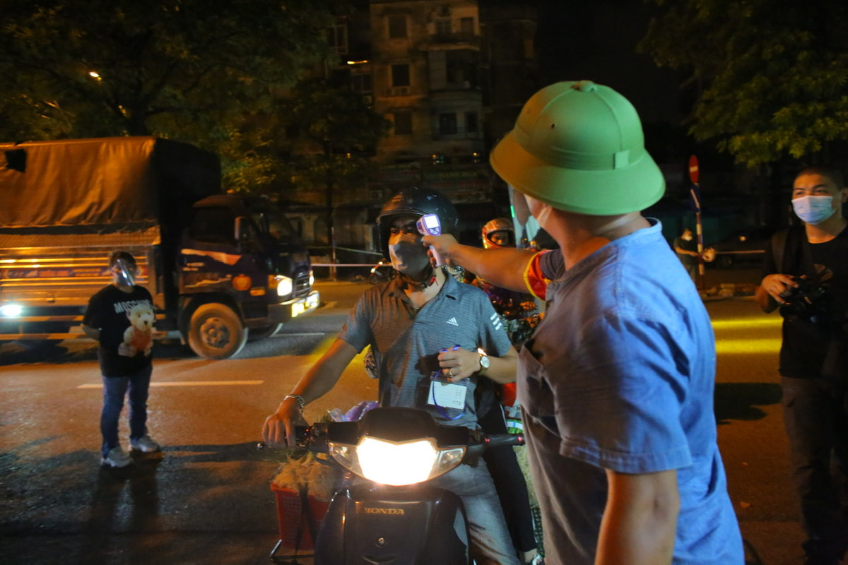 Tất cả mọi người ra vào chợ đều phải đo thân nhiệt.