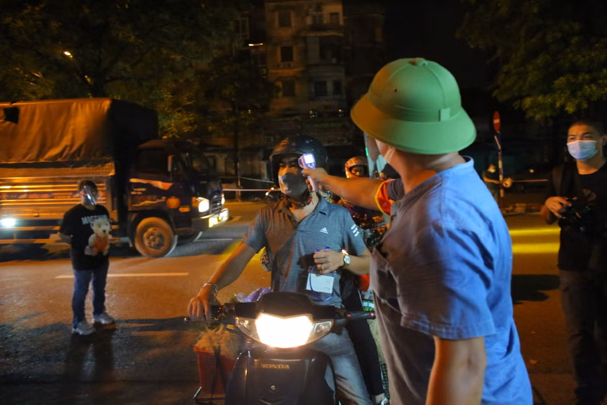 Tất cả mọi người ra vào chợ đều phải đo thân nhiệt.