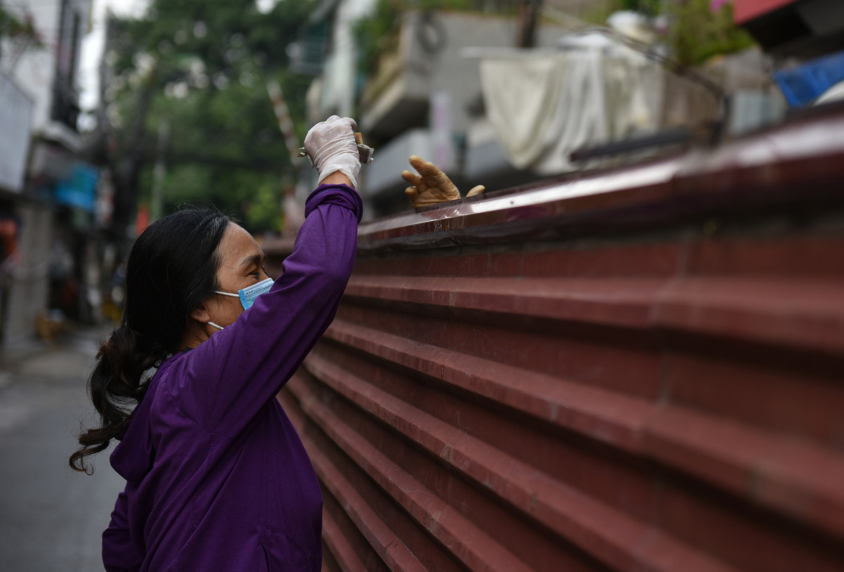 Họ bắc ghế, đu người mua đồ qua bức tường tôn.