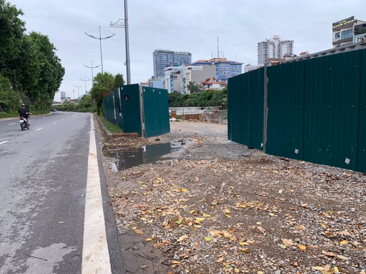 Vườn hoa ngăn cách đường đi bộ với trục đường chính cũng bị xén ra thành lối vào công trường.