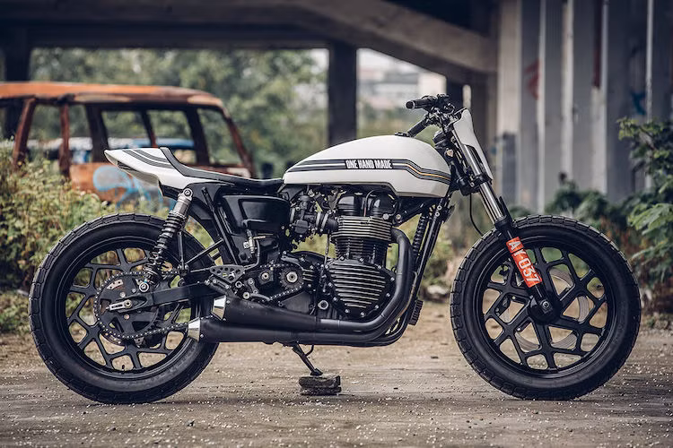 Bản độ Triumph Thruxton flat tracker này đã được đặt tên là Super Ten và tạo ra bởi Chun - một người đam mê xe tại Đài Loan và là chủ xưởng độ One Hand Made. Cách đây vài năm, một tai nạn môtô đã khiến Chun bị liệt gần như hoàn toàn tay phải, đó là lý do đứng đằng sau tên gọi One Hand Made.