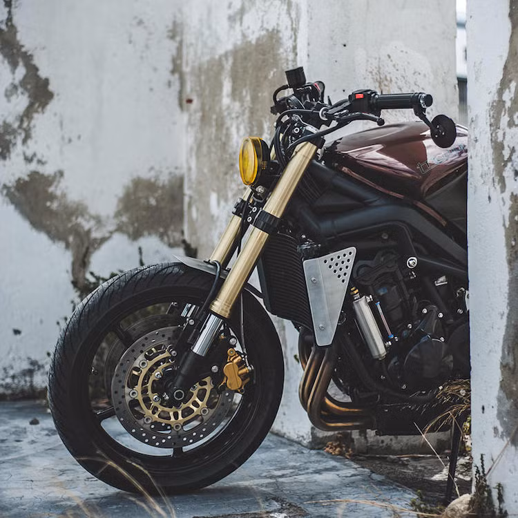 Thuộc phiên bản 2008, chiếc Triumph thuộc sở hữu của Kyle Scott - người điều hành hãng Wolf Moto. Để bắt đầu quá trình độ xe, Wolf Moto đã bỏ đi chi tiết đặc trưng nhất của Street Triple - đèn pha kép và thay vào đó là một đèn pha đơn LED siêu gọn được gắn thẳng vào thân xe.