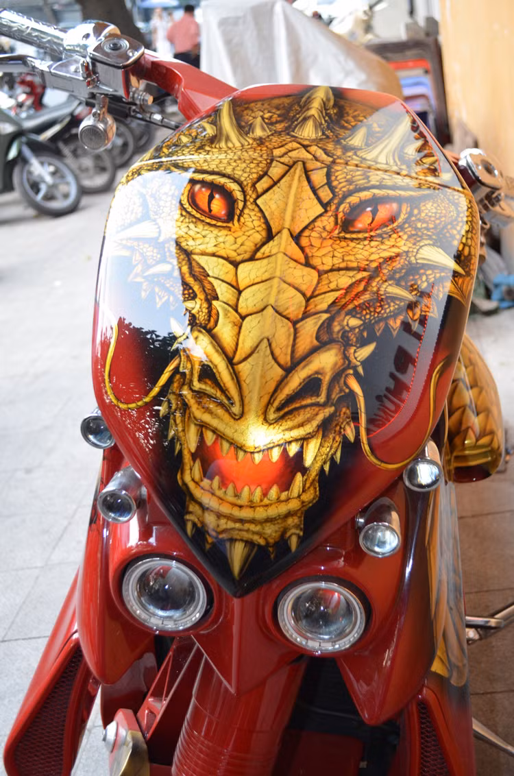 Sau khi được sơn lại, chiếc V-Rex đã được đổi sang màu đỏ, kèm theo những họa tiết hình một con rồng lửa dữ dằn như hiện nay. Trong đó, phần mặt nạ phía trước của xe được sơn mặt rồng đang chuẩn bị "thét ra lửa" cực sống động.