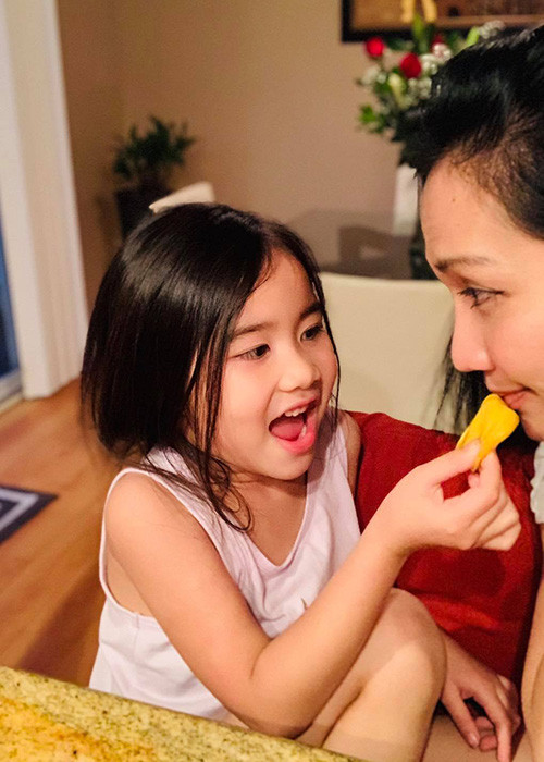 Bé Yvona có mái tóc dài mượt mà giống mẹ, rất thích làm nũng.