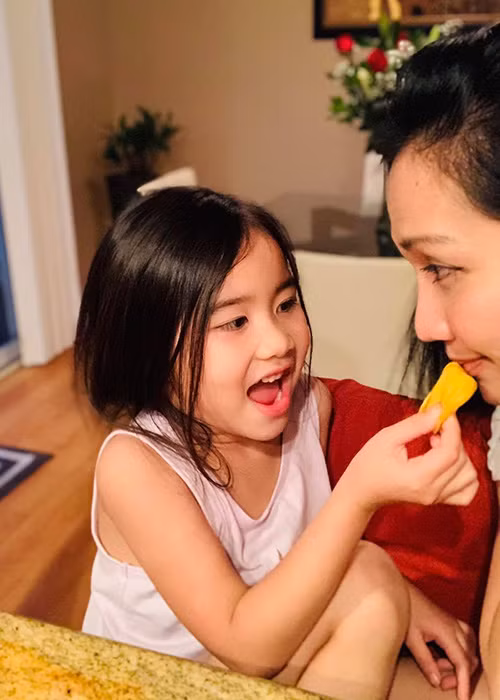 Bé Yvona có mái tóc dài mượt mà giống mẹ, rất thích làm nũng.