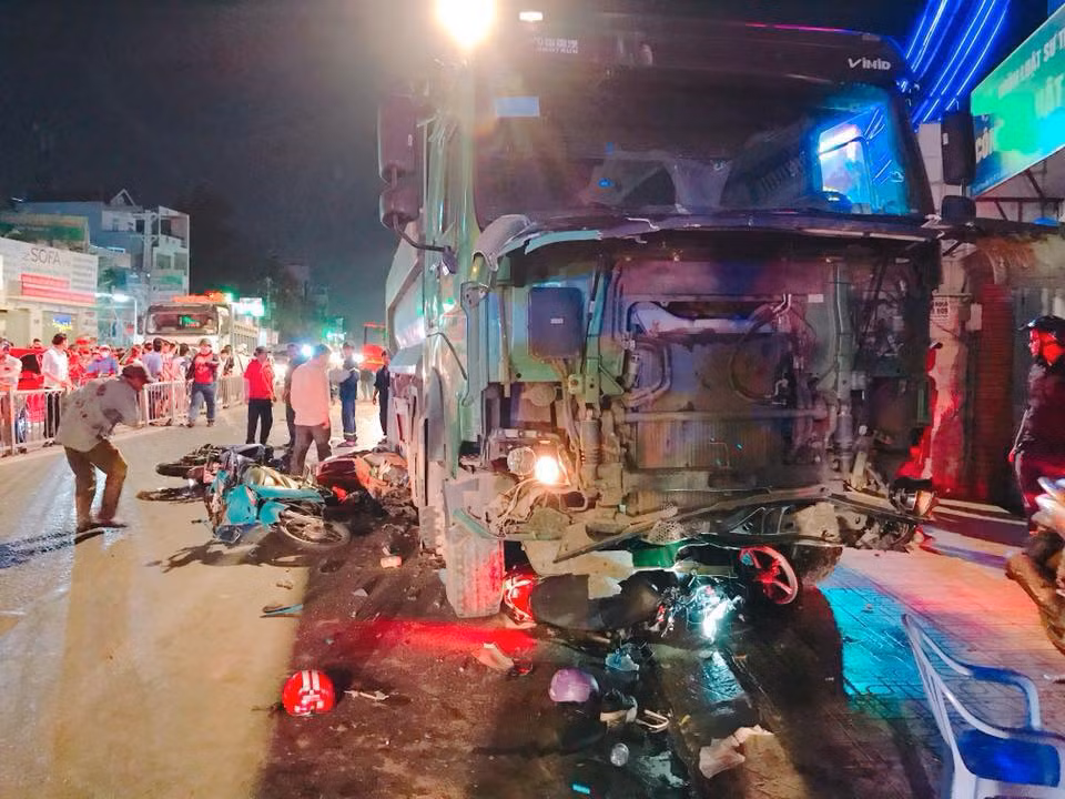 Hiện trường tai nạn giao thông kinh hoàng, đầu chiếc xe tải nát bấy, trong khi dưới gầm, bên cạnh xe la liệt các phương tiện và đồ dùng của nạn nhân.