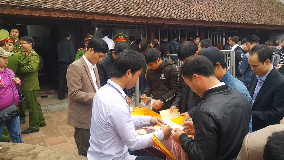 Những người mua được ấn đền Trần nhanh chóng đút vào túi bóng để giữ gìn trên hành trình về nhà.