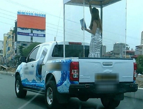 Người mẫu được đưa vào lồng kính diễu phố để quảng cáo cho mẫu điện thoại mới