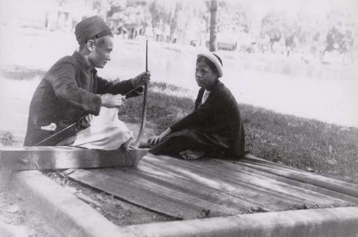 Gánh hát xẩm của nghệ sĩ mù bên bờ hồ Hoàn Kiếm. Ảnh: Musée de l'Homme.