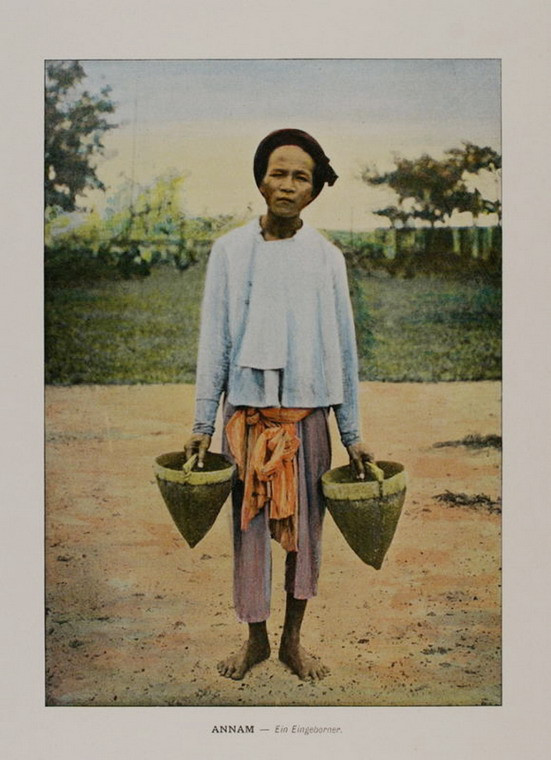 Người nông dân cầm đôi gầu dùng để tát nước.