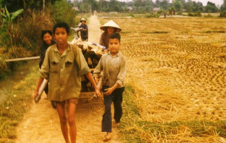 Hai cậu bé giúp gia đình kéo xe chở củi.