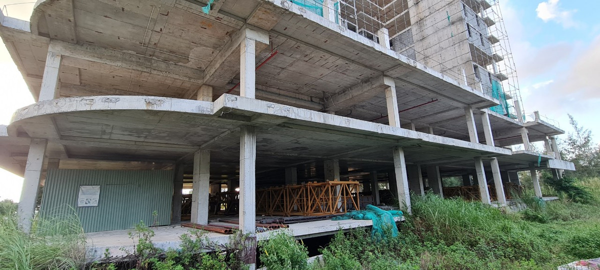 Nhiều hạng mục của dự án xây dựng dang dở thì tạm dừng, xung quanh cỏ mọc um tùm.