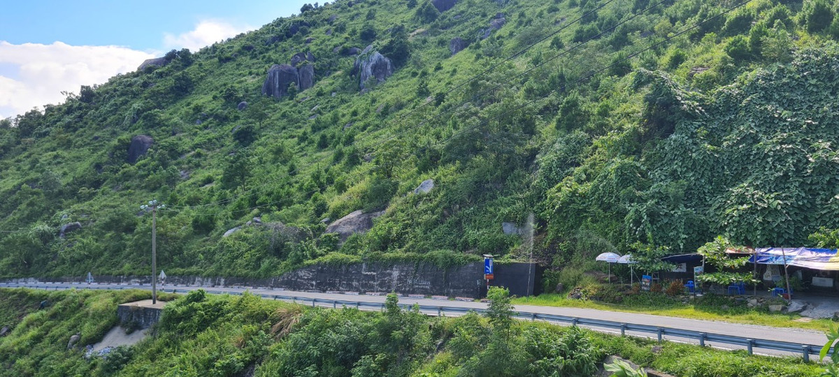ung đường đèo Hải Vân chênh vênh, nhiều khúc khuỷu, chạy uốn lượn ôm theo triền núi.