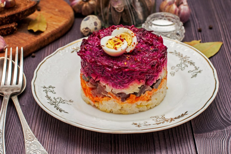 Thành phần chính của món salad này là cá trích muối, cùng với đó là các loại rau củ quen thuộc như củ cải đỏ, hành tây, khoai tây, cà rốt... Mỗi nguyên liệu được khéo léo cắt gọt, thái nhỏ rồi xếp thành từng lớp riêng biệt trong khuôn.