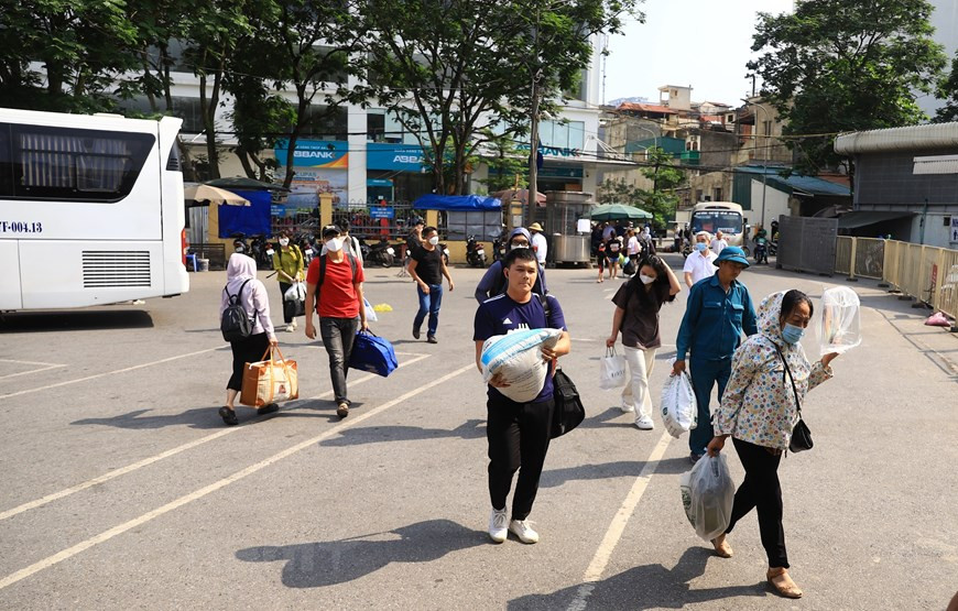 Tại bến xe Giáp Bát, người dân tay xách nách mang hành lý quay lại Hà Nội trong chiều 3/5. (Ảnh: Hoài Nam/Vietnam+) 