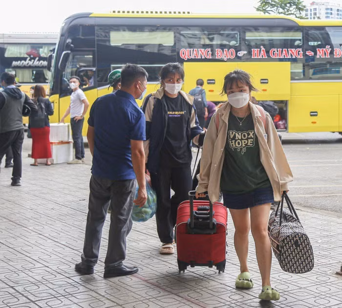 Từ xe khách người dân di chuyển sang các phương tiện khác để trở về nơi ở. (Ảnh: Báo Giao Thông)