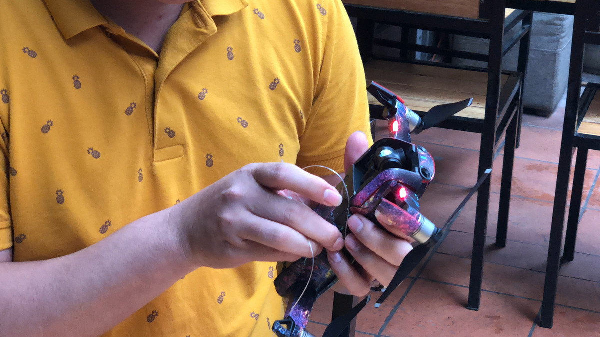 Để chuyển bánh flycam được buộc thêm 1 dây cước. Một đầu buộc vào pin của flycam.