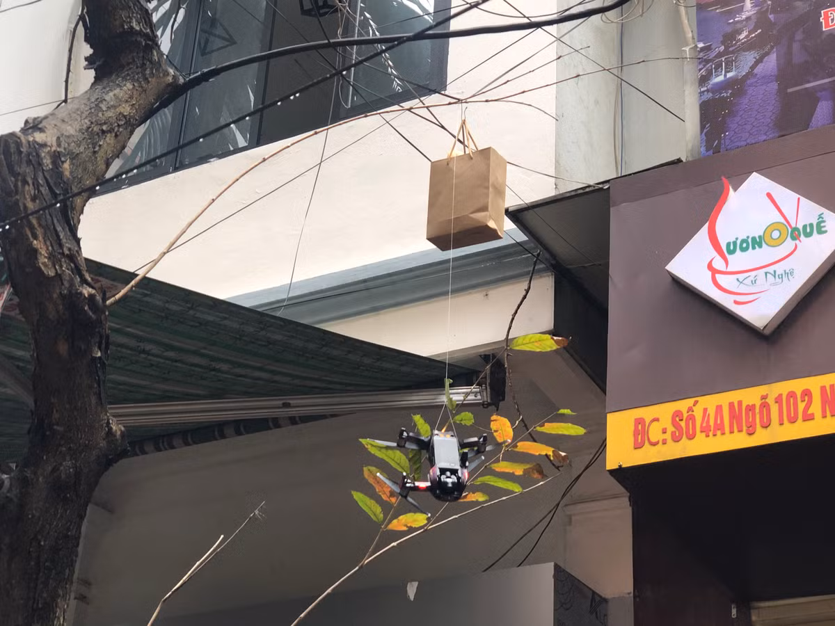 Lần bay thứ 1 thất bại, chiếc flycam bị vướng vào cành cây cạnh quán treo lơ lửng cùng bánh mì trong túi.