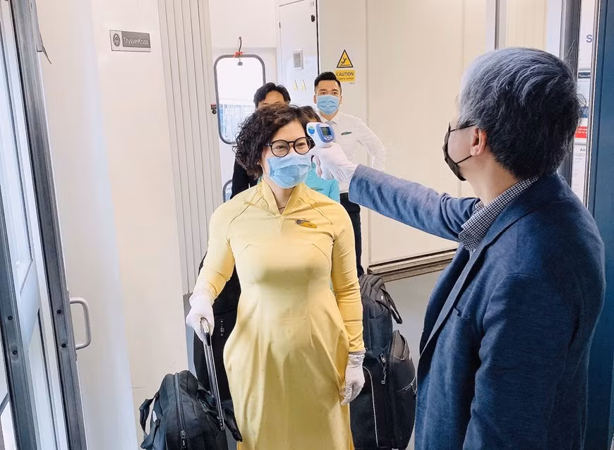 Toàn bộ thành viên trong tổ bay được kiểm tra thân nhiệt trước khi lên máy bay. (Ảnh: VNA cung cấp).