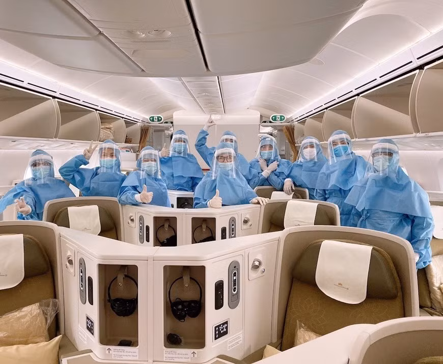 Các phi công, tiếp viên mặc trang phục bảo hộ trước khi thực hiện chuyến bay. (Ảnh: VNA cung cấp).