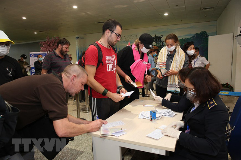 Đối với hành khách ngoại quốc hoặc chưa năm rõ sẽ được hướng dẫn viên thông thạo ngoại ngữ hướng dẫn cụ thể, đảm bảo hàng khách có thể khai đầu đủ và chính xác. (Ảnh TTXVN)