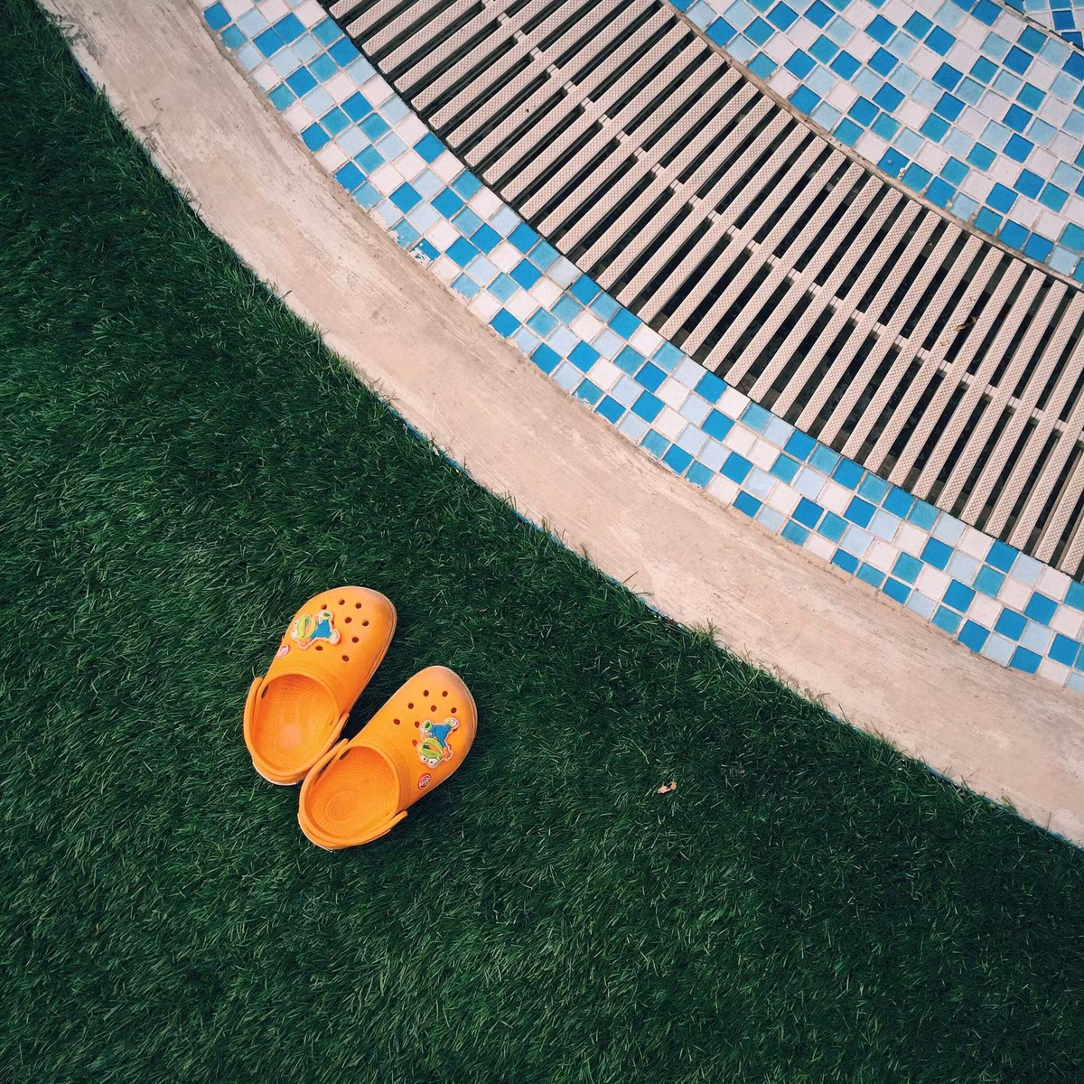 iphone 6 không phải chiếc điện thoại với sức mạnh camera góc rộng, Tuy vậy, nó cũng đủ với những ai sáng tạo và khéo léo chọn khung hình. Tấm hình được Hà Phong chụp đôi dép của cậu con trai cạnh bể bơi. Sự khéo léo từ khuôn hình tới màu sắc, một ý ảnh đáng yêu nhè nhẹ. (Ảnh: Hoàng Gia Hà Phong)