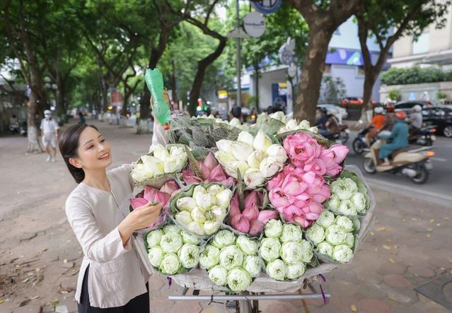 Hình ảnh "cô hàng hoa Vũ Diệu Thảo" với chiếc áo bà ba, quần lụa, cùng chiếc xe chở đầy hoa sen khiến nhiều người thích thú (Ảnh: Hòa Nguyễn).