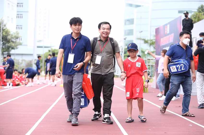 Những ông bố trẻ đưa bé đến sân bóng cũng phấn khích và hồi hộp không kém con trai...