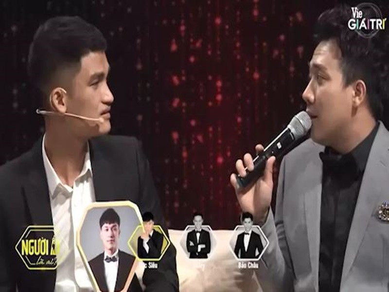 Ở Người ấy là ai do Trấn Thành dẫn dắt, Mạc Văn Khoa so sánh mình với một anh chàng Việt kiều điển trai: "Bạn cũng giống tôi, có nét của người đàn ông có gia đình, thành đạt, mạnh mẽ, làm gì cũng không giấu được nét đàn ông của mình". Nghe vậy, Trấn Thành chen vào: "Lại sảng đậu rồi". Khi Mạc Văn Khoa tiếp tục trò chuyện với nhân vật chính: “Yêu một người đẹp rất khổ”, Trấn Thành lại chen vào: “Như bạn gái Khoa là sướng đó". Không im lặng, Mạc Văn Khoa thừa nhận: "Đúng vậy, bạn gái tôi đang rất sướng vì yêu một người xấu như tôi". Ảnh: Vietnamnet