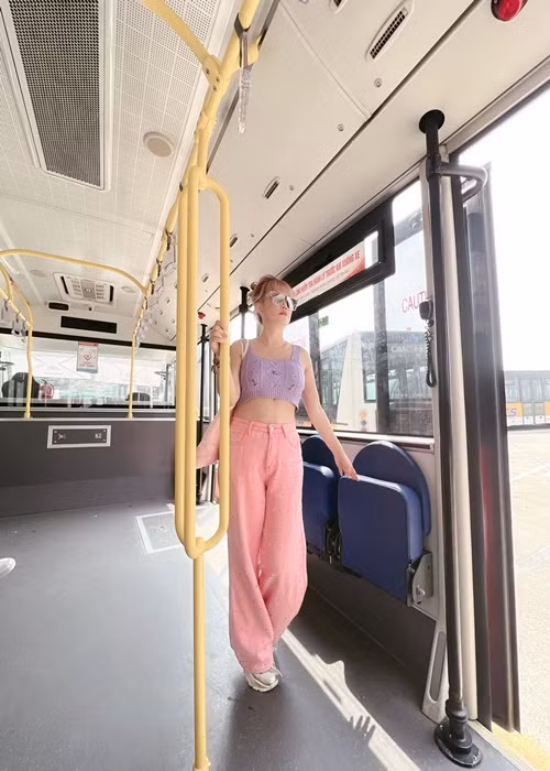 Cô kết hợp áo crop top với quần ống rộng, giày thể thao.