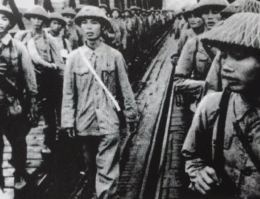 Chính trị viên Vũ Huy Hậu (người ở giữa ảnh, đi đầu) cùng cán bộ, chiến sĩ Tiểu đoàn Bình Ca qua cầu Đuống về tiếp quản Hà Nội sáng 8/10/1954.