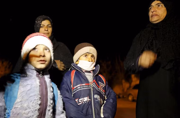 Các em nhỏ cùng người thân lặn lội đêm khuya rời thị trấn.