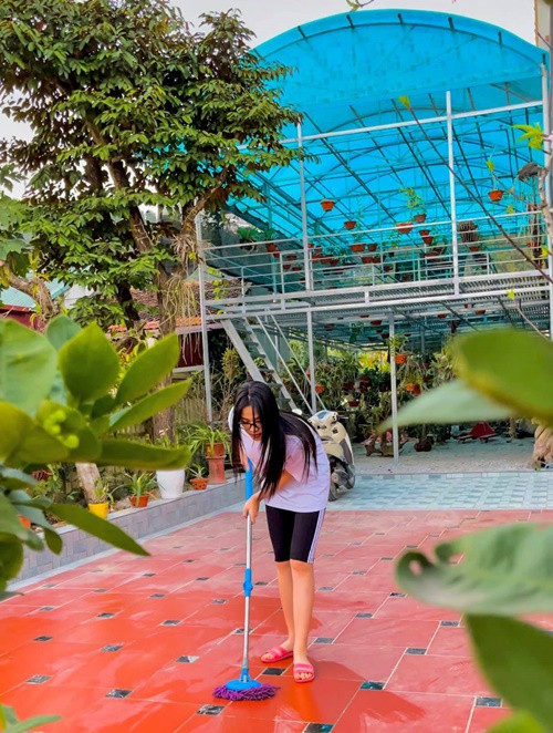 Đỗ Thị Hà mặc đơn giản khi lau dọn sân nhà. Ảnh: FB Đỗ Thị Hà.