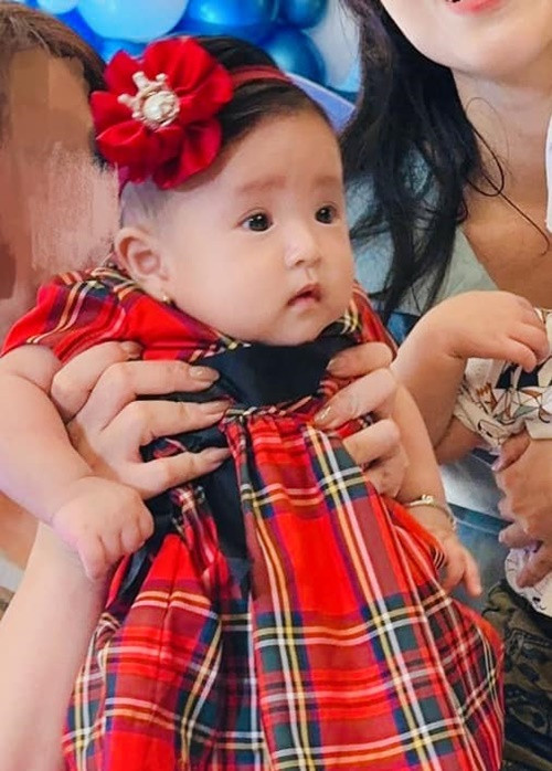 Con gái Thanh Trúc mặc váy, đeo nơ tóc điệu đà.