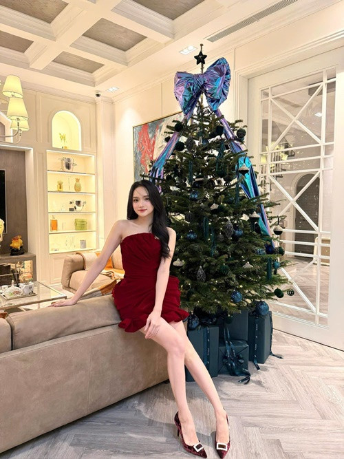 Nàng hậu gợi cảm trong chiếc váy ngắn tông đỏ, tạo dáng bên cây thông.