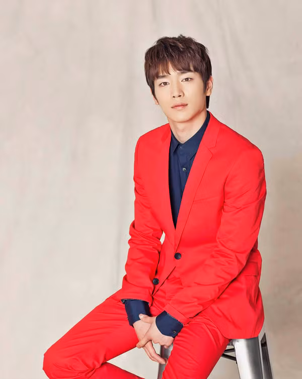 Seo Kang Joon diện vest đỏ sặc sỡ trên nền áo sơ mi tối màu.