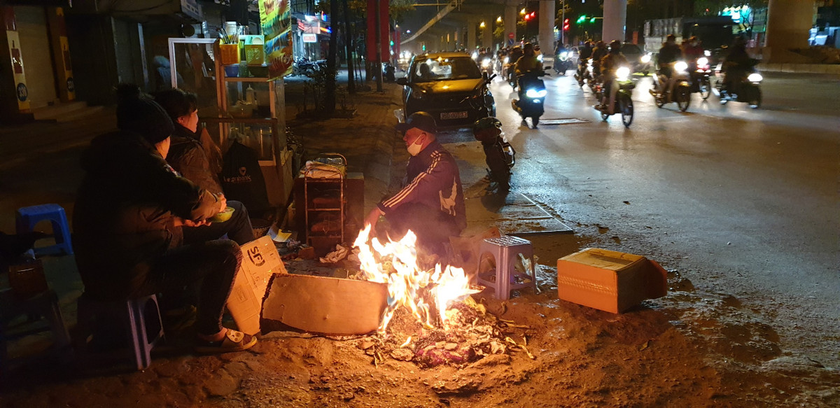 Phần đông các điểm bán đồ ăn vặt dọc tuyến phố Hà Nội đều đốt lửa để sưởi ấm và thu hút khách.