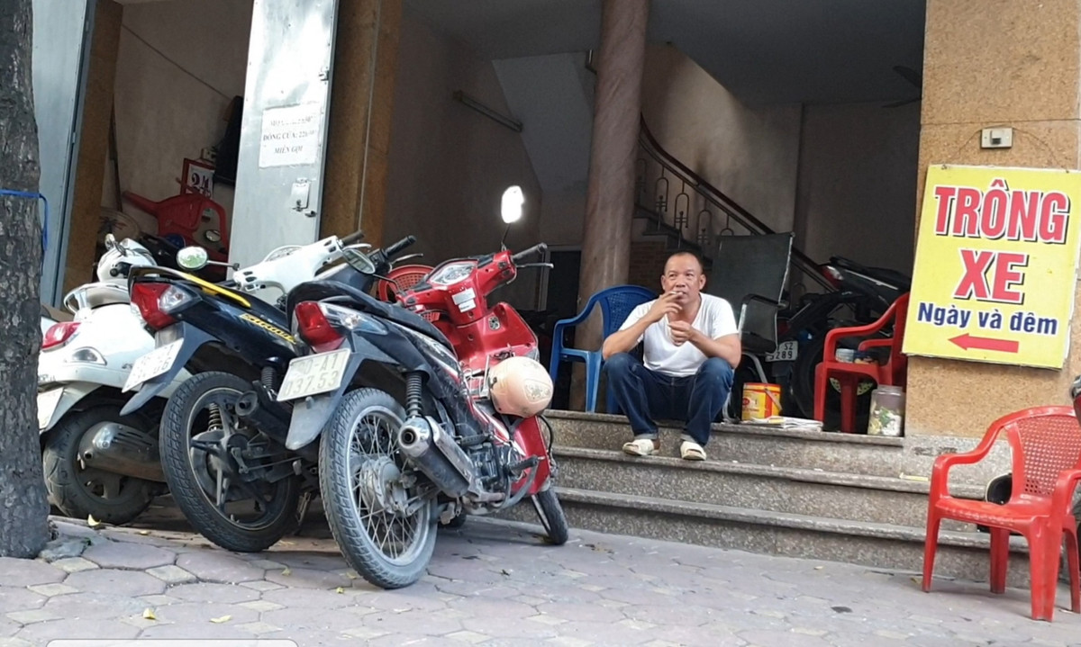 Mọi góc ngách của căn nhà được tận dụng để trông giữ xe máy ngày và đêm. Người đàn ông trông giữ xe thản nhiên hút thuốc ngay sát hàng dài xe máy bất chấp nguy hiểm cháy nổ