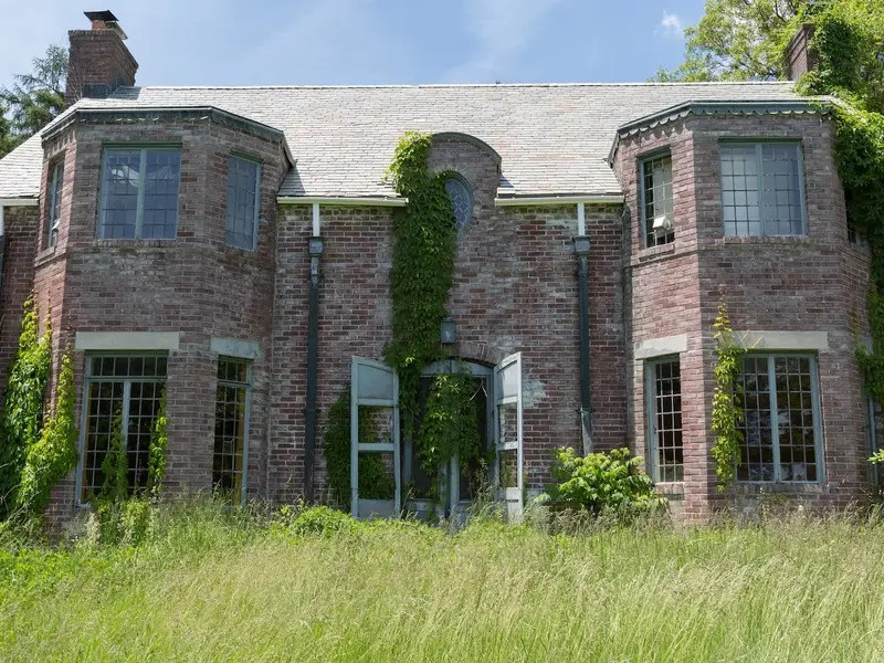 Clown House (Mỹ), được xây dựng vào những năm 1920, còn có biệt danh là "ngôi nhà chú hề" tại Catskill. Tuy có màu sắc rực rỡ, ngôi nhà lại trở nên khác thường và đáng sợ. Ngày nay, dinh thự vẫn nằm trong dãy núi Catskill, bị bỏ mặc cho thảm thực vật xâm chiếm, trở thành một trong những địa điểm bỏ hoang đáng sợ nhất. Ảnh: Insider.