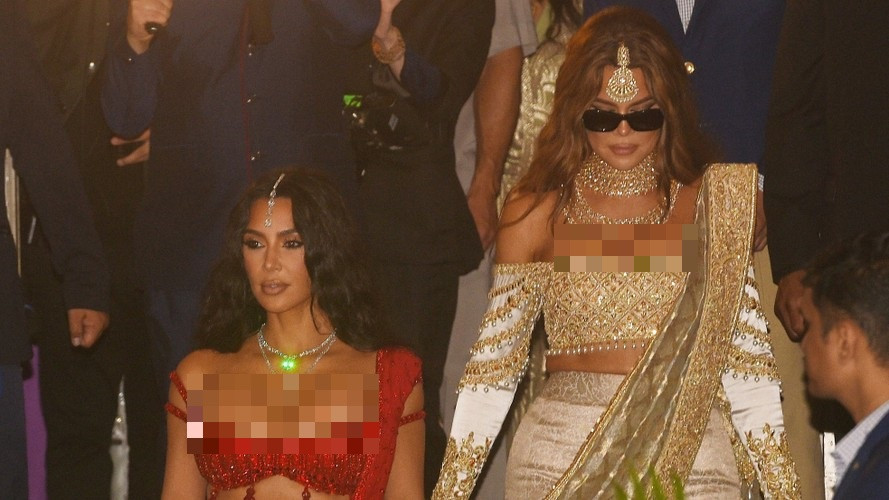 Chị em Kim Kardashian và em gái Khloe Kardashian dự cưới bằng những trang phục nổi bật. Kim diện bộ đồ màu đỏ anh đào, Khloe lựa chọn trang phục vàng và trắng, kết hợp cùng trang sức nhiều lớp từ Polki.