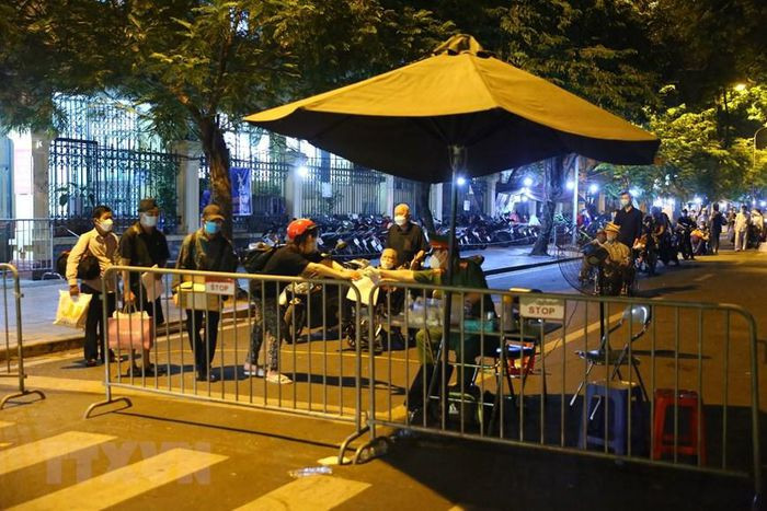 Lực lượng chức năng lấy thông tin khai báo y tế của những người đủ yêu cầu được phép xuất viện. (Ảnh: Hoàng Hiếu/TTXVN)